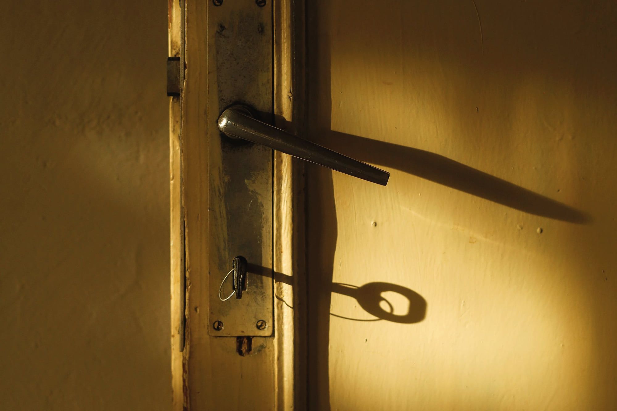 Une clé sur la serrure d’une porte, dans la lumière dorée.