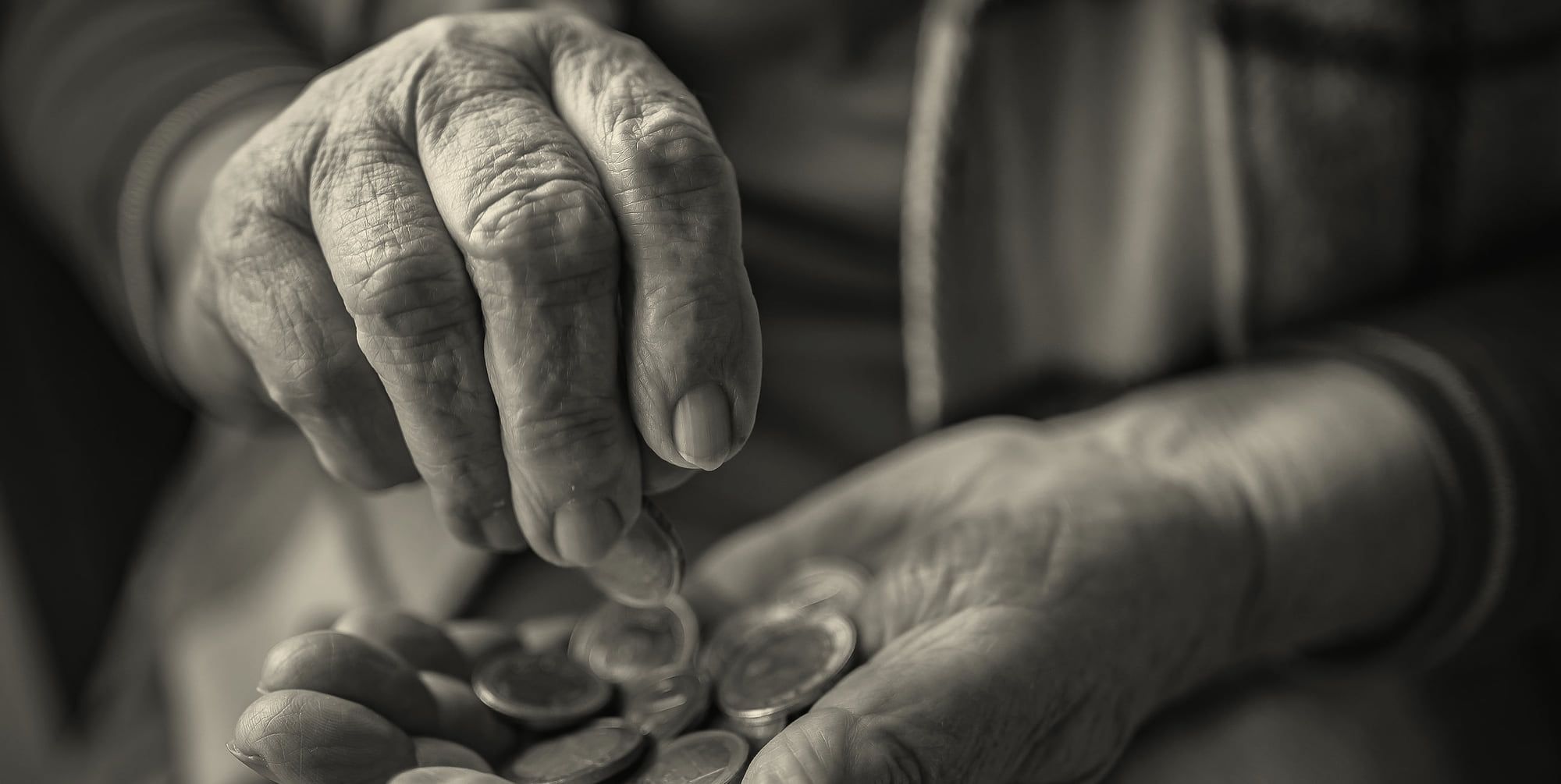Des mains âgées comptent quelques pièces de monnaie.